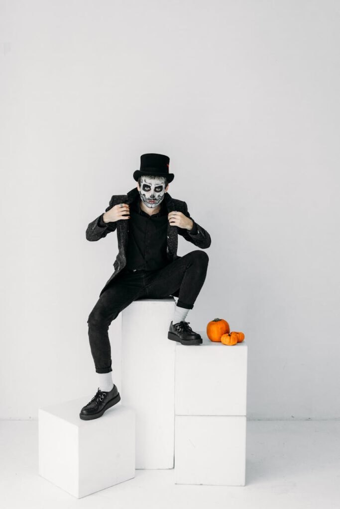 man in black suit sitting on white wall